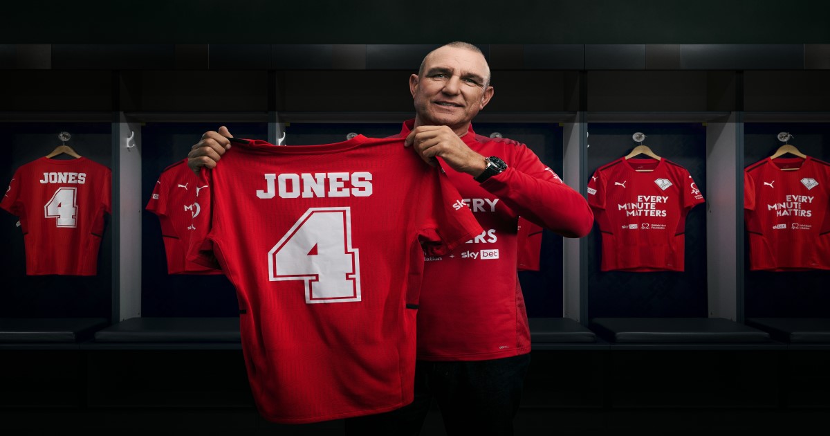 Vinnie jones holding up his football tshirt 