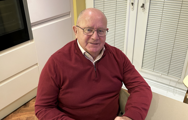 Photograph of John Pengelly. He is sitting in a chair looking into the camera.