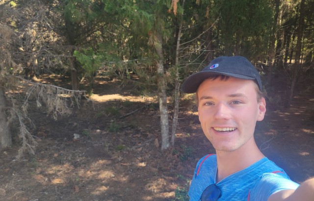 Matt Ralph in a blue cap and t-shirt smiling at the camera