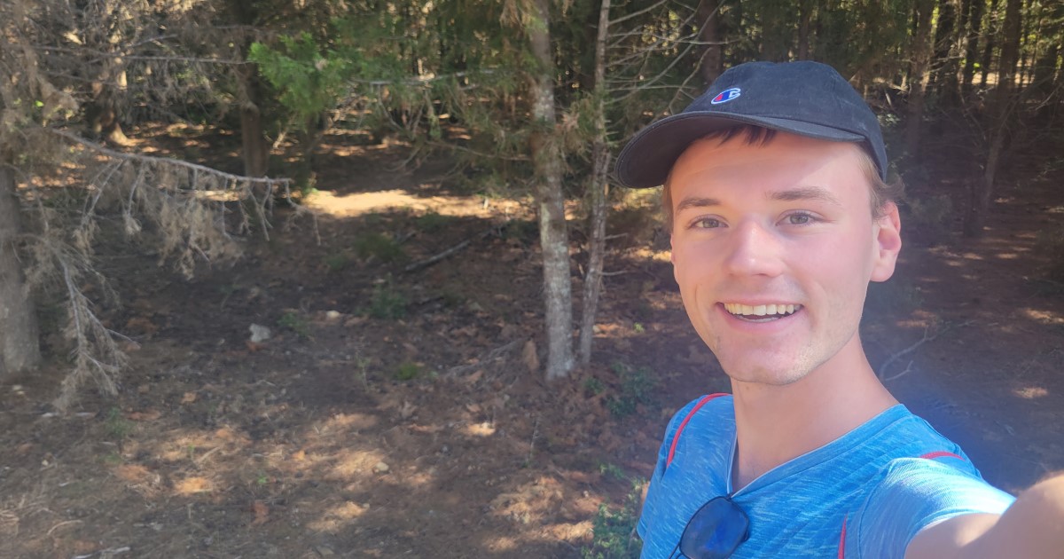 Matt Ralph in a blue cap and t-shirt smiling at the camera 