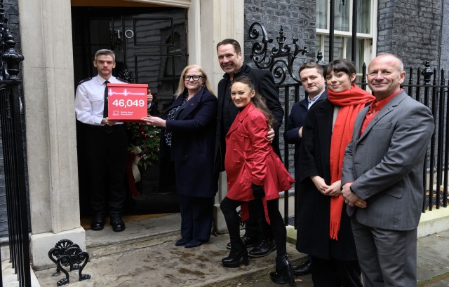 BHF CEO Dr Charmaine Griffiths, David and Frankie Seaman, Hugh Matthews, Tara Deboys, and James Wilkinson hand in a box full of 46,000 signatures to a security guard at 10 Downing Street