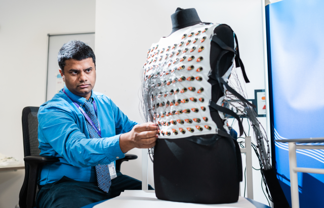 Dr George Joy, lead author of the study, inspects the ECGI vest on a mannequin. Credit: UCL Institute of Cardiovascular Science / James Tye