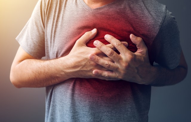 A man clutches his chest with both hands