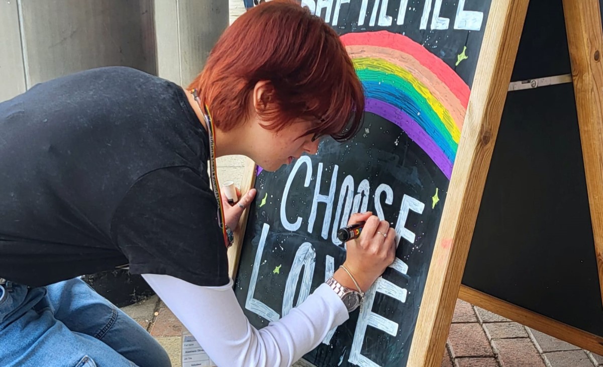 BHF volunteer, Anastacia, 17, decorating a chalk board outside the Hemel Hempstead shop.