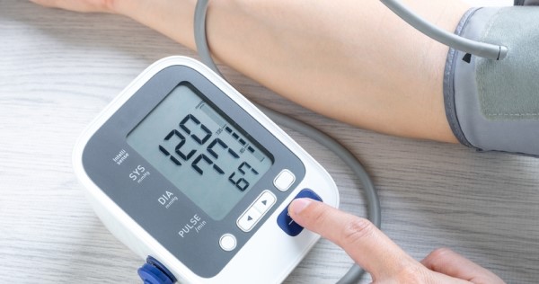 A person using a blood pressure monitor on their arm