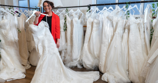 BHF shop manager Sally Todd with the rails of wedding dresses