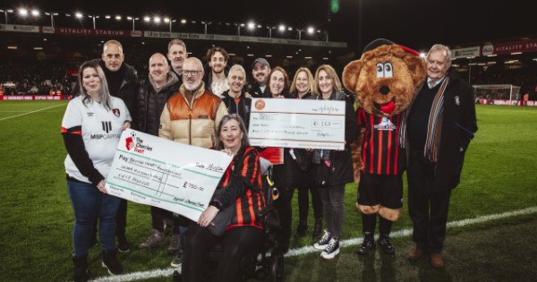 Luton Town and AFC Bournemouth supporters clubs handing over two cheques to the British Heart Foundation.