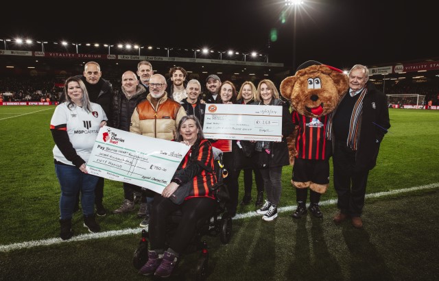Luton Town and AFC Bournemouth supporters clubs handing over two cheques to the British Heart Foundation.
