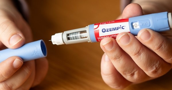 Two hands open an Ozempic injection