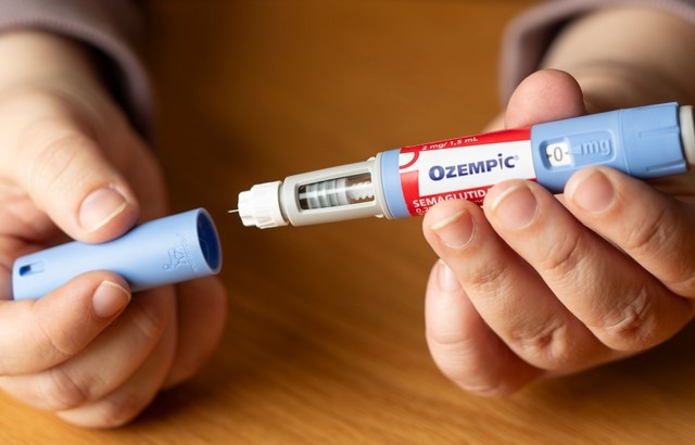 Two hands open an Ozempic injection