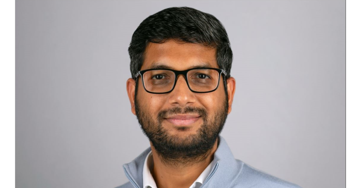 Professor Nikhil Paliwal smiling in front of a grey background