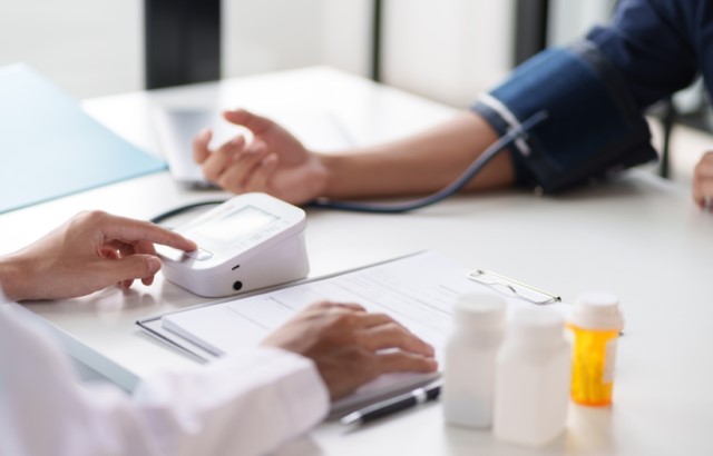 A doctor checks a patient's blood pressure