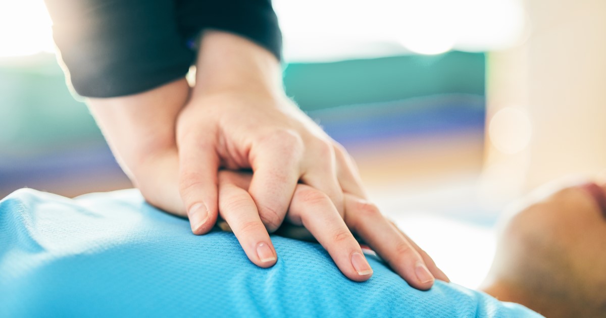 Stock image of model performing chest compressions on unconscious patient.
