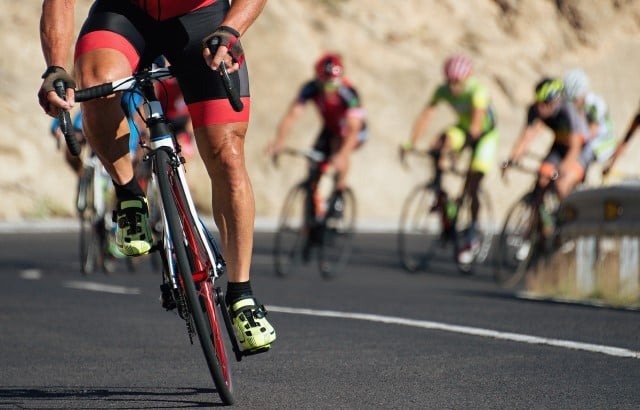 Photo of a group of professional cyclists riding up a hill