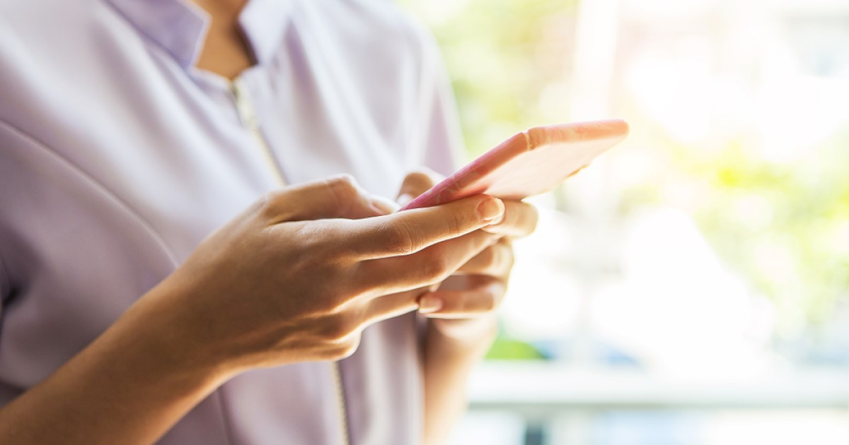 A nurse is shown holding a smart phone