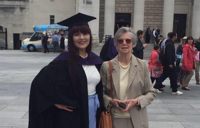 A young woman, Ellie Harries, graduating university standing with her grandmother