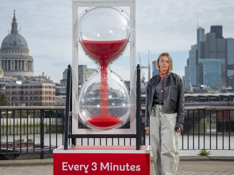 Actress Lisa McGrillis stands by the giant Every 3 minutes egg timer unveiled at London's Southbank