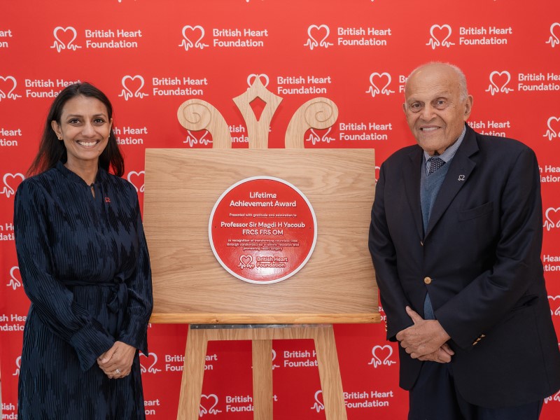 Dr Sonya Babu-Narayan and Professor Sir Magdi Yacoub stand either side of his Lifetime Achievement Award plaque from the BHF