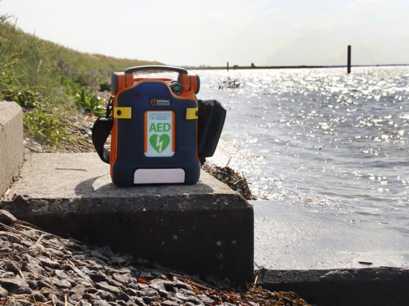A defibrillator pictured on steps down to the seafront in Great Yarmouth. There is a pier in the far background. 