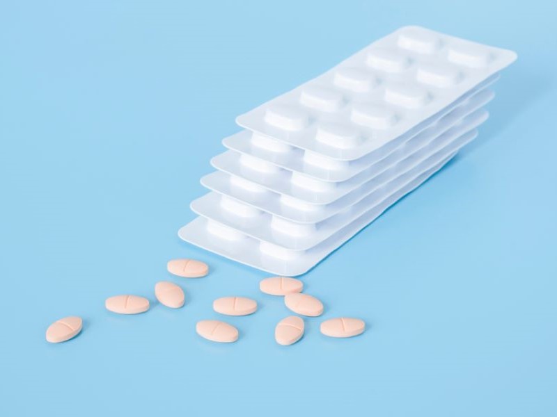 Statin pills and a stack of blister packs that hold them