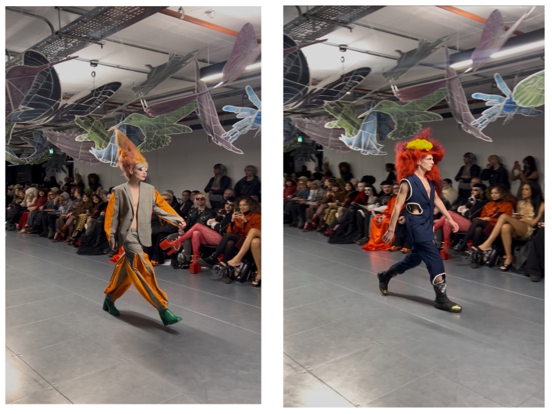 Two pictures side by side, of two models walking down the catwalk in Vin + Omi's collection. Model on the left has orange hair and wearing an orange and grey suit. Model on the right has red hair and wearing a blue suit with cut out detailing.