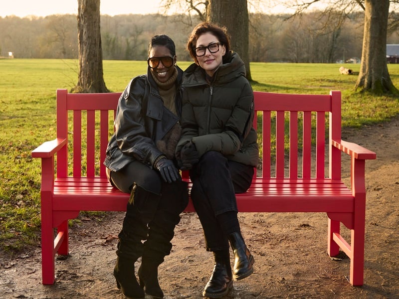 TV presenter Emma Willis sits on a BHF red bench with cardiovascular disease survivor Michelle White