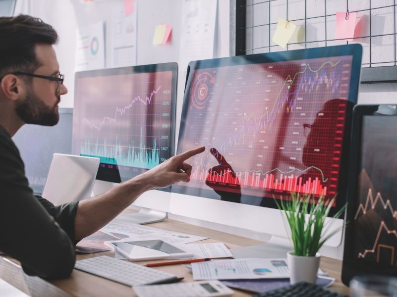 Man pointing to a computer screen which is displaying academic data