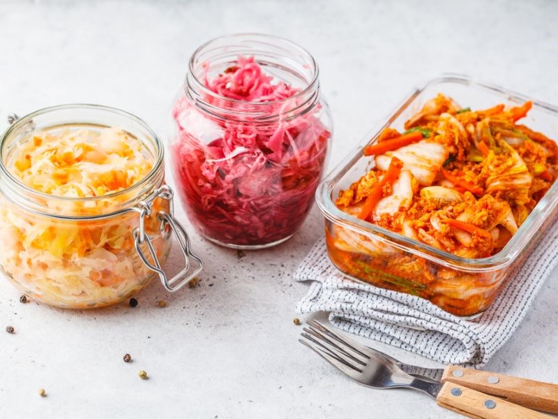 Jars of kimchi and sauerkraut on a counter top