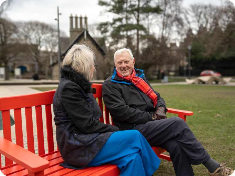 Sue Webber, MSP for Lothian Region, Scotland, with her father, Jimmy, on a BHF red bench sharing their heart stories.