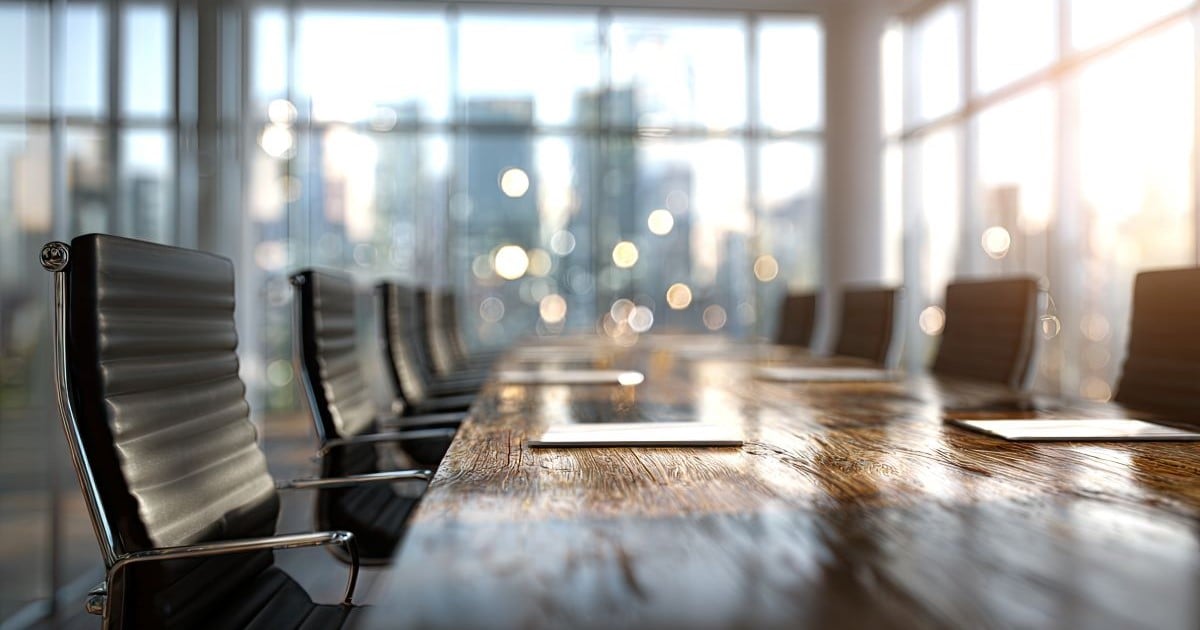 A boardroom table with several chairs around it