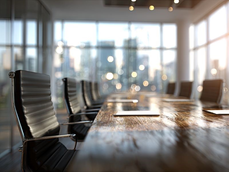 A boardroom table with several chairs around it