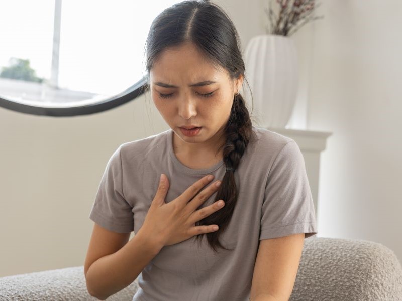 Photograph of a woman clutching her chest 