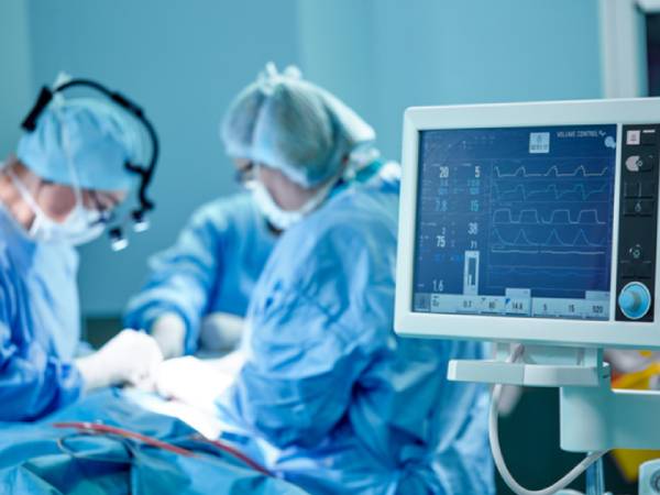two doctors performing heart surgery in an operating theatre