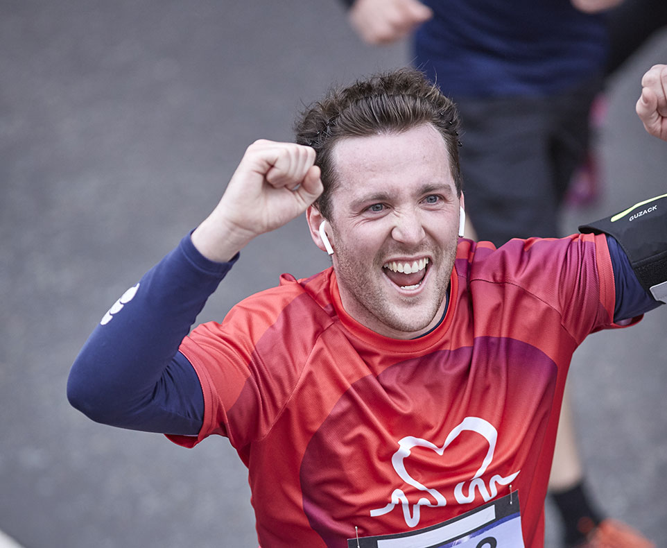 Person running in a race with arms in the air