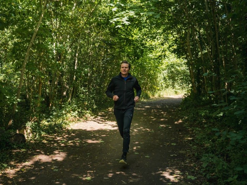 Olympian Roger Black jogging in is local woods.