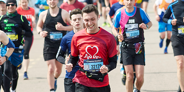 Man in BHF top celebrates crossing the line